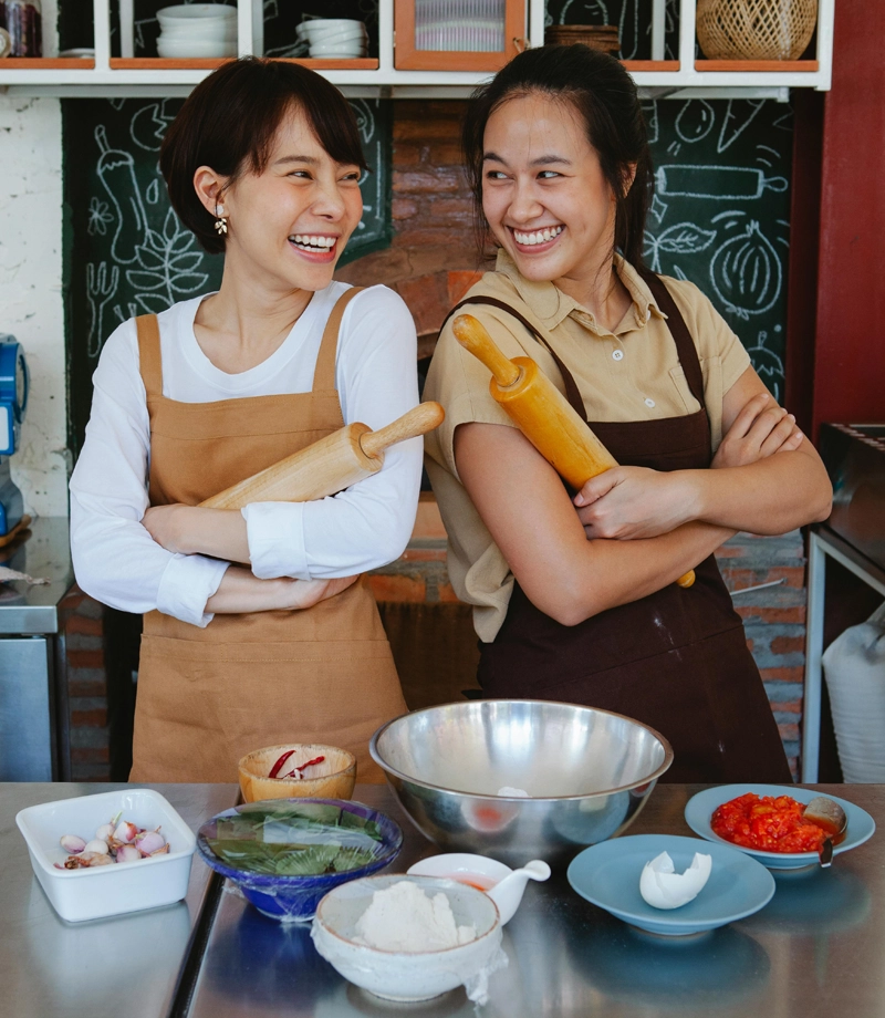 two-bakers-smiling-at-each-other Two bakers, back-to-back, happy about their work.